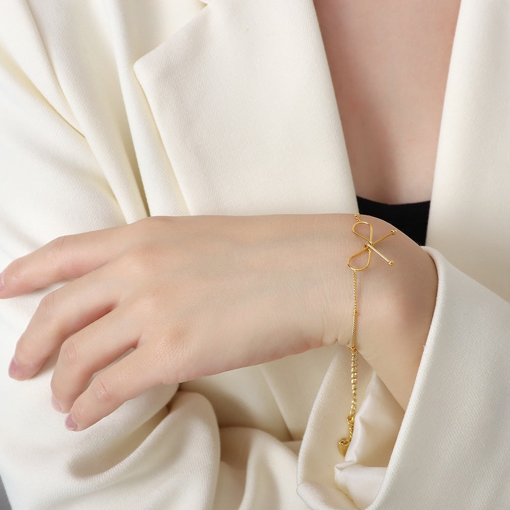 Valantomode | Plated Symmetrical Bow Bracelet with Linear Ribbon Structuralism