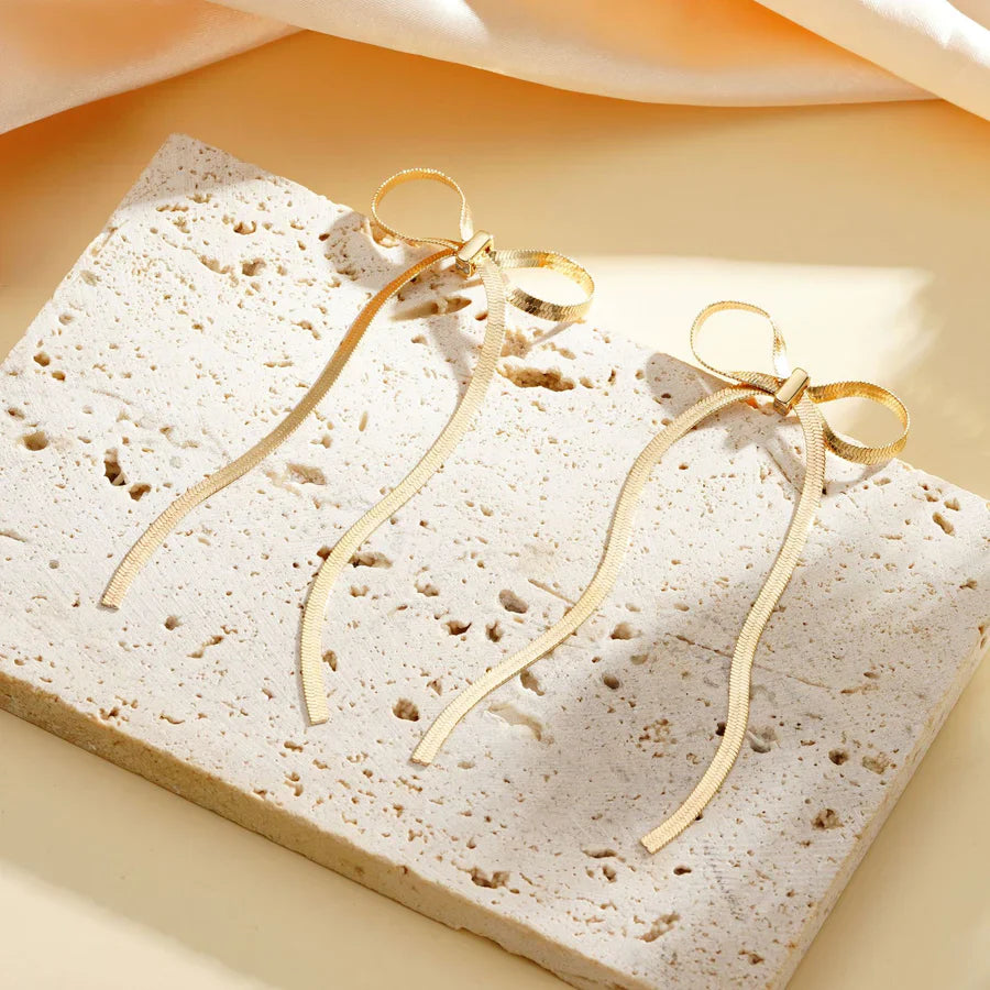 Valantomode | Plated Bow Earrings with Asymmetric Loop Architecture and Linear Geometry